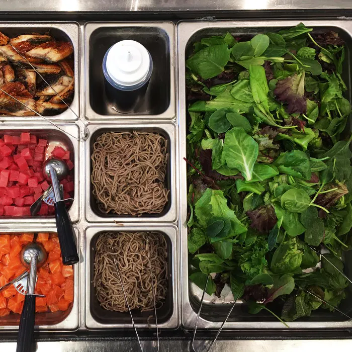 Poke station with marinated eel, soba noodles, mixed greens, and cubed salmon and tuna portions at Poke Makana, a Hawaiian restaurant in Sherwood